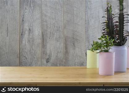 various plant painted recycle cans wooden table