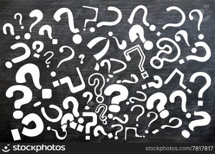 Various question marks on a smudged blackboard