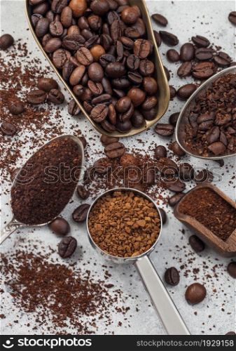 Various scoops with ground and bean coffee and freeze dried instant coffee granules on white background. Top view