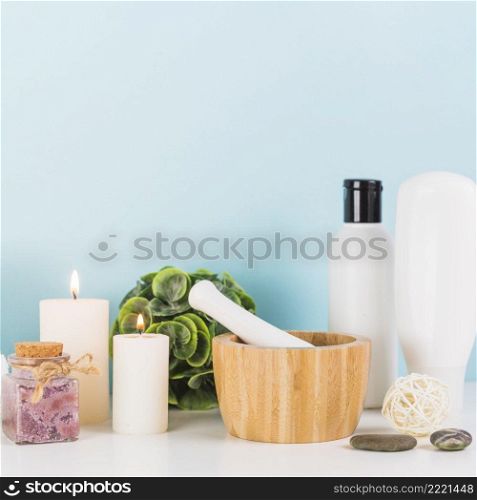various spa products with illuminated candles mortar pestle white tabletop