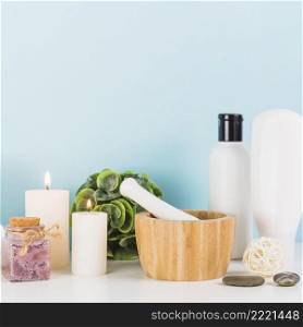 various spa products with illuminated candles mortar pestle white tabletop