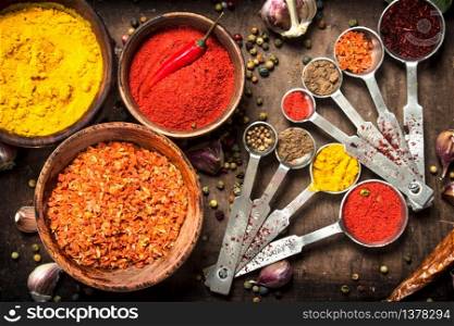 Various spices and herbs in a wooden tray. On a rustic background.. Various spices and herbs in a wooden tray.