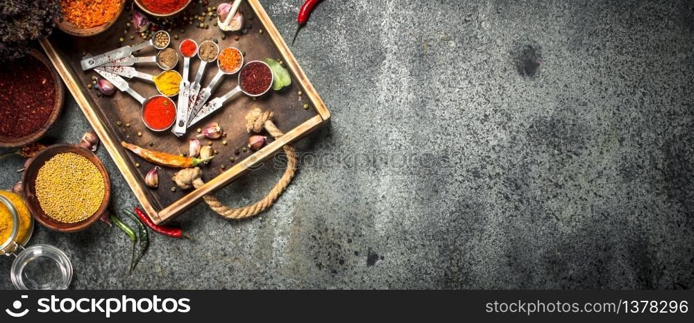 Various spices and herbs in a wooden tray. On a rustic background.. Various spices and herbs in a wooden tray.