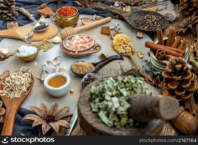 Various spices and herbs in rustic style with honey on balck background. Natural herbs medicine, Organic herbal and healthy concept, Selective focus.