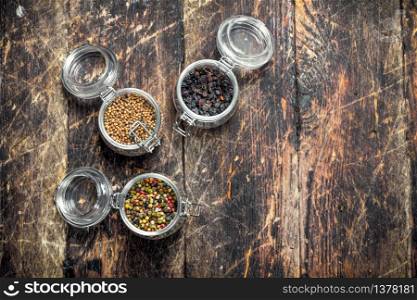 Various spices in glass jars. On a wooden background.. Various spices in glass jars.