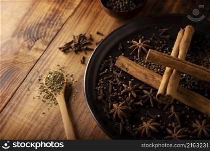 Various spices on wooden rustic board background. Pepper, cardamom, clove, cinnamon, star anis, dehydrated parsley. Close up