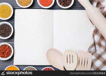 Various spices selection and notepad for copy space on wooden table