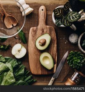 Various succulent plants and Fresh organic ingredients for salad making and wooden spoons with glass salad bowl on rustic background, top view. Flat lay with place for text. Vegan and healthy food concept. Fresh organic ingredients for salad making on rustic background