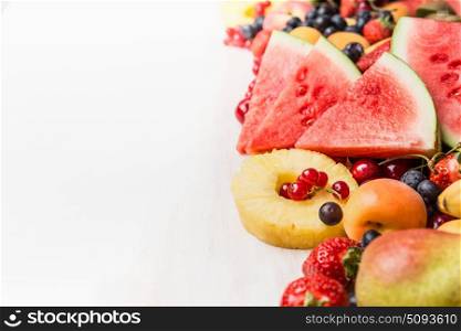 Various summer fruits and berries on white table background. Healthy food and vegetarian eating concept