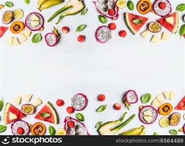 Various summer tropical fruits slices frame on white background, top view, flat layout. Concept of healthy food and eating