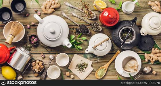 Various tea and teapots composition, dried herbal, green, black tea and matcha tea on wooden table background, flat lay