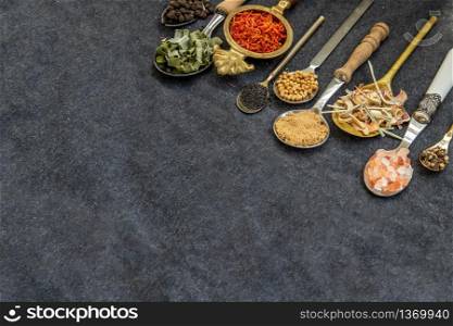 Various teas and dried herbs assortment on spoons in rustic style on balck background. Organic herbal, Selective focus, Copy space.