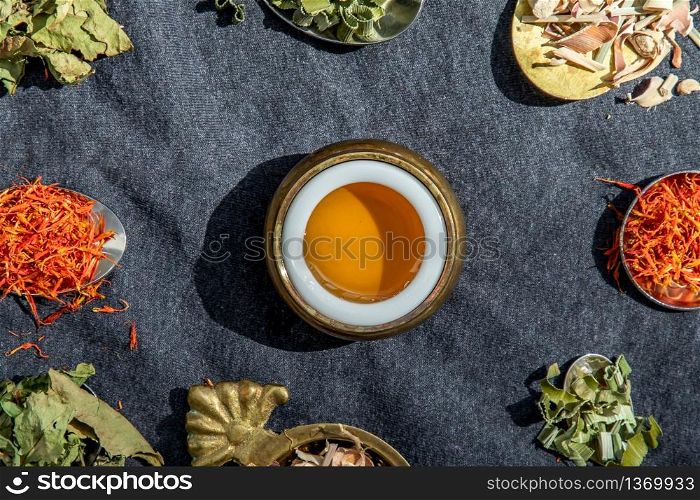 Various teas and dried herbs assortment on spoons in rustic style with honey on balck background. Organic herbal, Selective focus.