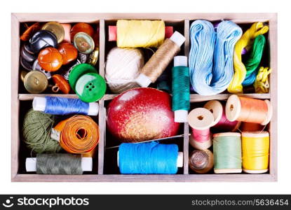 various threads and sewing tools in box isolated on white background