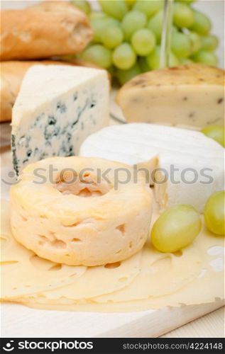 Various Types of Cheese and Grapes on Wooden Chopping Board