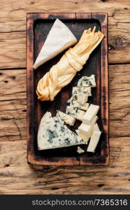 Various types of cheese on rustic wooden table. Delicious cheese on the table