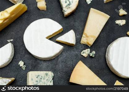 Various types of cheese - parmesan, brie, roquefort, cheddar on concrete background or table. Various types of cheese - parmesan, brie, roquefort, cheddar