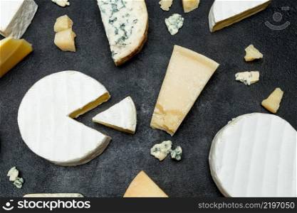 Various types of cheese - parmesan, brie, roquefort, cheddar on concrete background or table. Various types of cheese - parmesan, brie, roquefort, cheddar