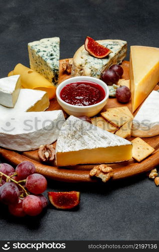 Various types of cheese - parmesan, brie, roquefort, cheddar on wooden cutting board. Various types of cheese - parmesan, brie, roquefort, cheddar