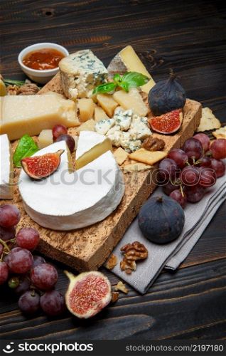 Various types of cheese - parmesan, brie, roquefort, cheddar on wooden cutting board. Various types of cheese - parmesan, brie, roquefort, cheddar