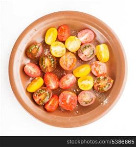 Various types of cherry tomatoes on the plate, isolated on white