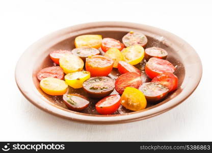 Various types of cherry tomatoes on the plate. Tomato salad on white table