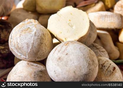 Various types of goat cheese on wooden desk. Various types of cheese