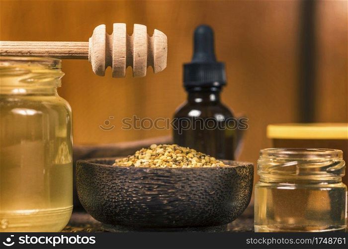 Various types of honey, bee pollen, propolis and wooden honey dipper on table. . Honey and Bee Products