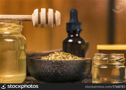 Various types of honey, bee pollen, propolis and wooden honey dipper on table. . Honey and Bee Products