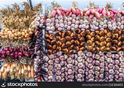 Various types of onion, garlic and chili peppers arranged in a vegetable market