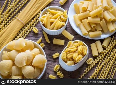 Various types of pasta on the wooden background