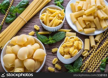 Various types of pasta on the wooden background