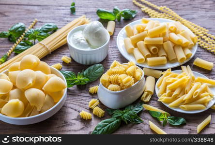 Various types of pasta on the wooden background