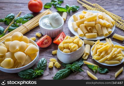 Various types of pasta on the wooden background