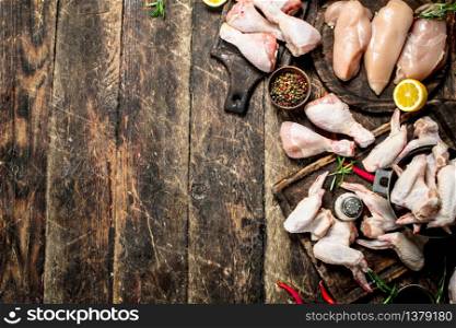 Various types of raw chicken meat with herbs .On wooden background.. Various types of raw chicken meat with herbs in a bowl.
