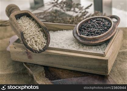 Various types of rice : Brown rice, Jasmine rice and Riceberry on old wooden background. Organic raw rice collection, Healthy food and diet concept, Selective focus.