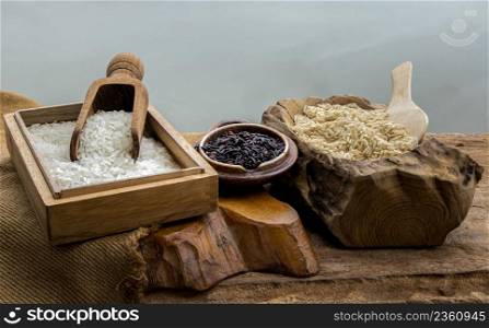 Various types of rice : Brown rice, Jasmine rice and Riceberry on old wooden table. Organic raw rice collection, Healthy food and diet concept, Selective focus.