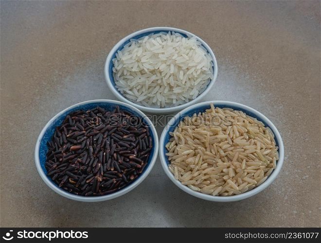 Various types of rice : Brown rice, Jasmine rice, Riceberry ceramic cup. Organic raw rice collection, Healthy food and diet concept, Selective focus.