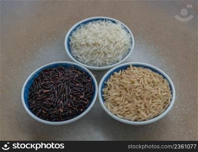 Various types of rice : Brown rice, Jasmine rice, Riceberry ceramic cup. Organic raw rice collection, Healthy food and diet concept, Selective focus.