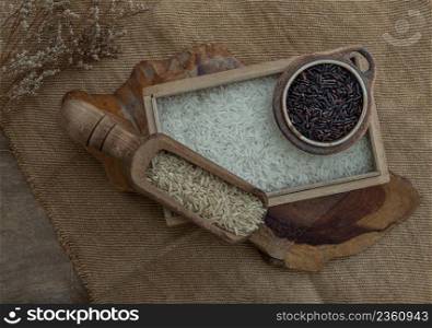 Various types of rice : Brown rice, Jasmine rice, Riceberry on old wooden background. Organic raw rice collection, Healthy food and diet concept, Overhead view, Selective focus.