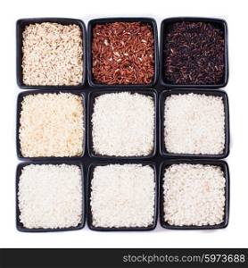 Various types of rice in black bowls isolated on white. Various types of rice