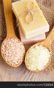 Various types of spa sea salt and soap in wooden spoons closeup
