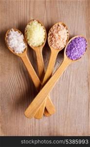 Various types of spa sea salt in wooden spoons closeup
