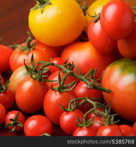 Various types of tomatoes on wooden background