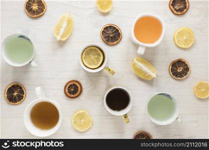 various types tea ceramic cup dry grapefruit slices with lemon wooden background