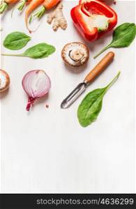 various vegetables ingredients for salad or healthy cooking with peeler on white wooden background, top view