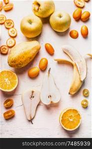 Various yellow and orange colors fruits flat lay on white desk, top view. Healthy food.