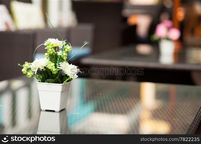 Vase of flowers placed on a table in a restaurant.
