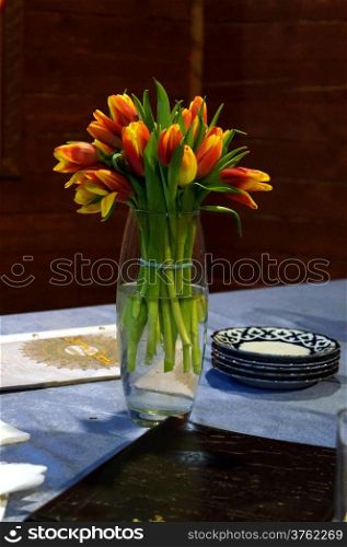 Vase of tulips on a table in a cafe