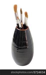 Vase with brushes of the artist on a white background